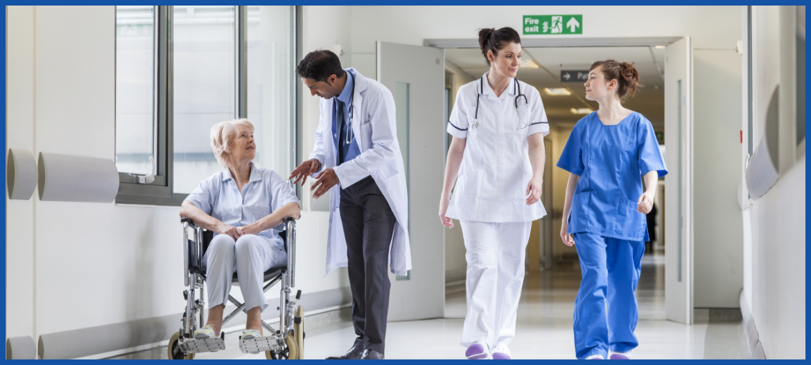 Doctors and nurses walking down a corridor with a patient in a wheelchair